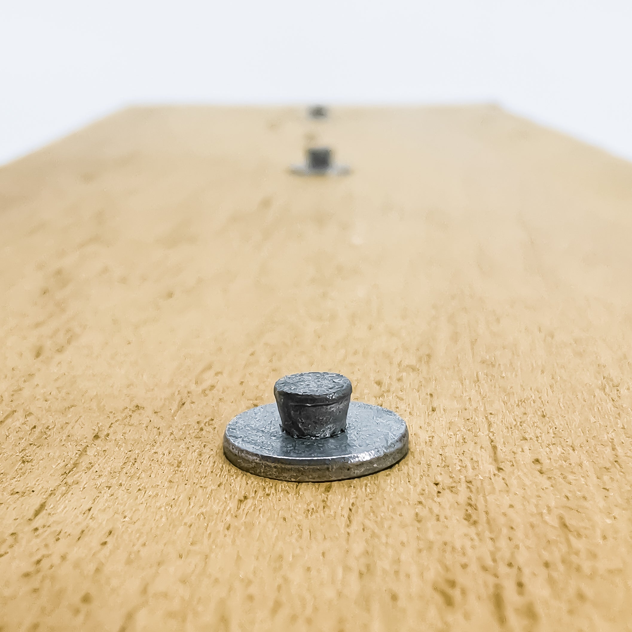 Washered masonry nail fitted into timber base material